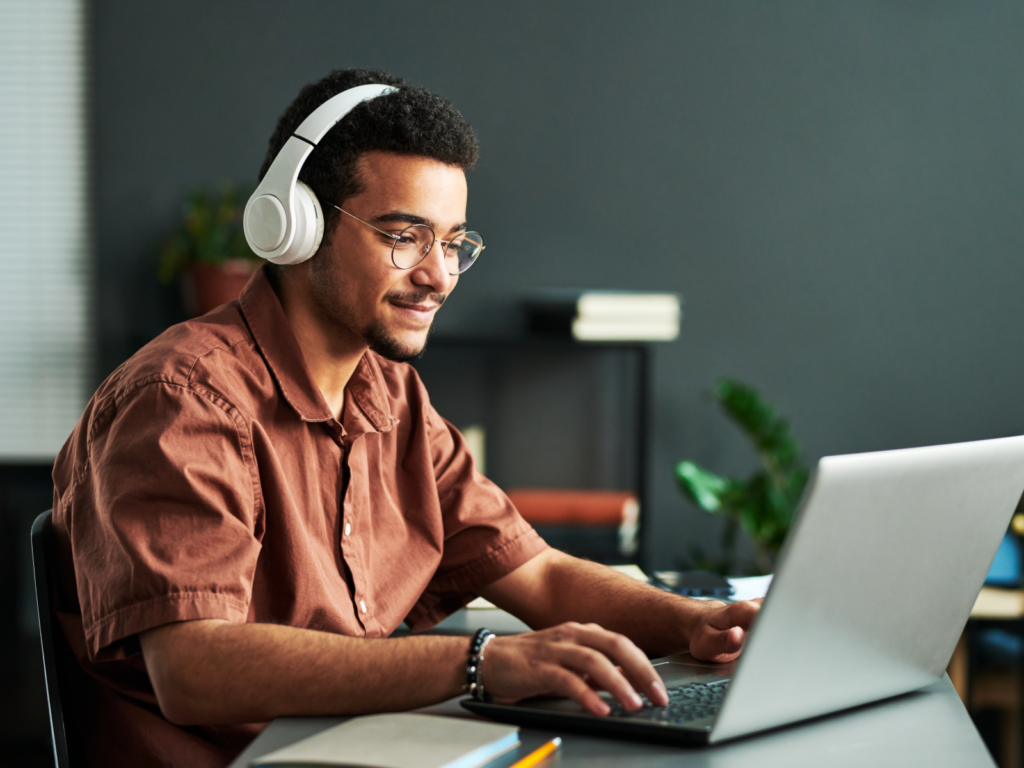 WooCommerce SEO tips Man in headphones works on his laptop, researching WooCommerce SEO strategies.